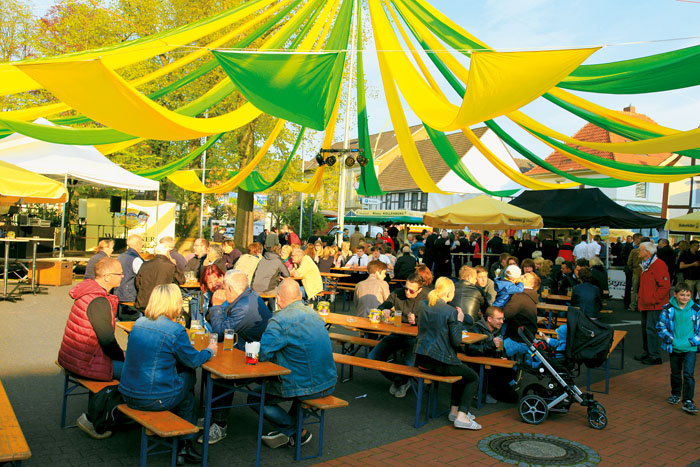 Bei den lauschigen Temperaturen ließen sich die Besucher der Maikirmes allzu gern unter dem bunten Fahnenhimmel nieder, um a