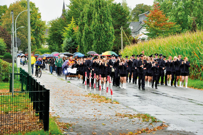 Feucht fröhlich im Regen marschieren die Klosterdörfler mit dem Spielmannszug Neuenkirchen an der Spitze über die Schulstr