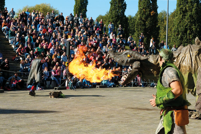 Drache Fangdorn macht dem Schurken Ronni Feuer unterm Allerwertesten: Viele Besucher verfolgen das Schauspiel in der Volksban